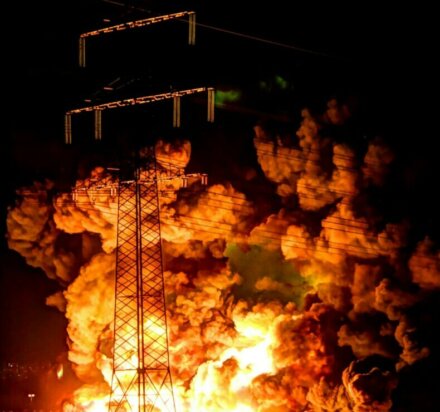 zdjęcie przedstawia pożar w nocy na głównym planie znajduje się wieża przewodząca linie prądu